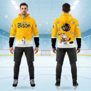 Bloomington Bison Peanuts Hoodie with a vibrant yellow design, Snoopy playing hockey, team logo, & snowflakes.